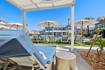 Poolside cabana with lounge chairs and blue cushions